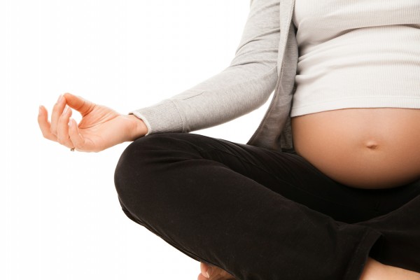 Pregnant woman relax doing yoga over white